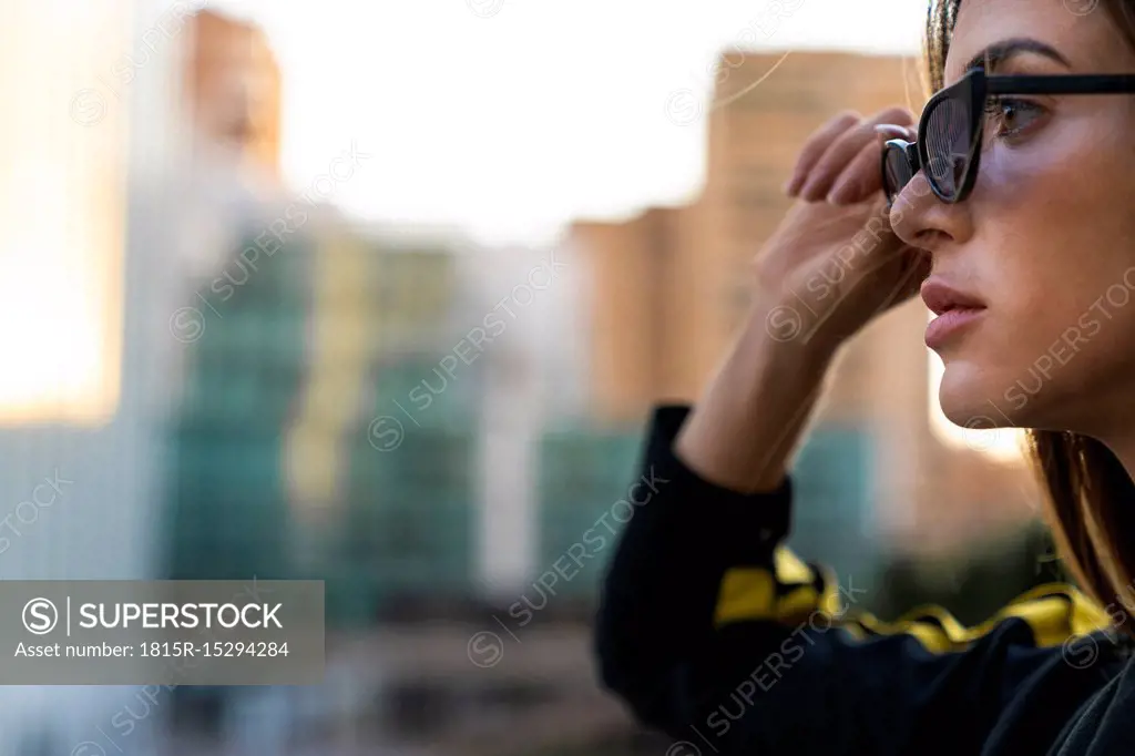 Portrait of attractive young woman wearing sunglasses in the city