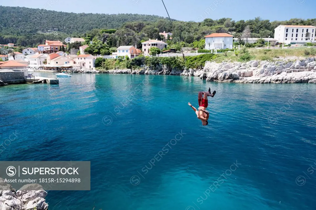 Croatia, Istria, Losinj, Rovenska, Young man bungee jumping