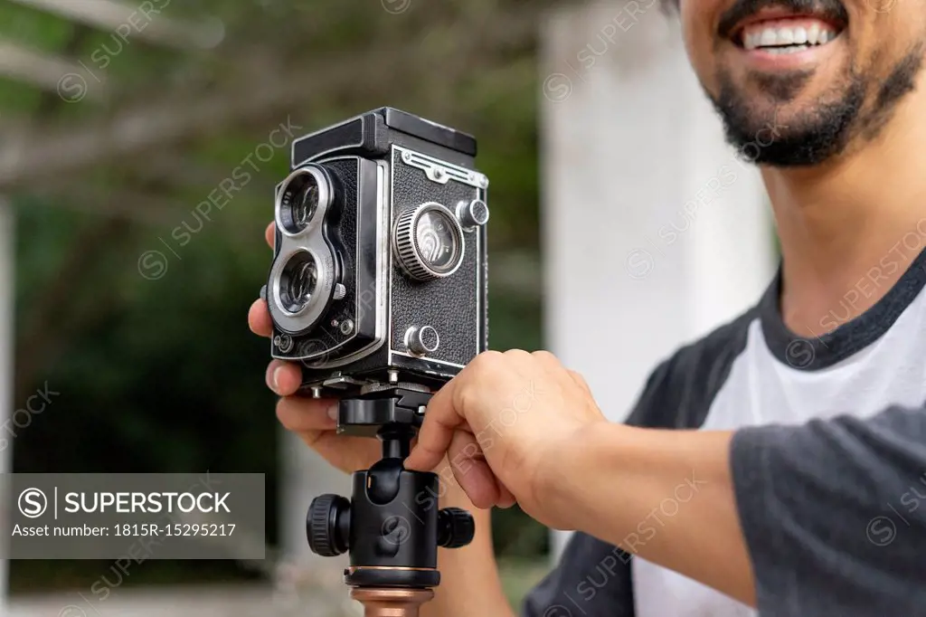 Close-up of happy young man using vintage camera