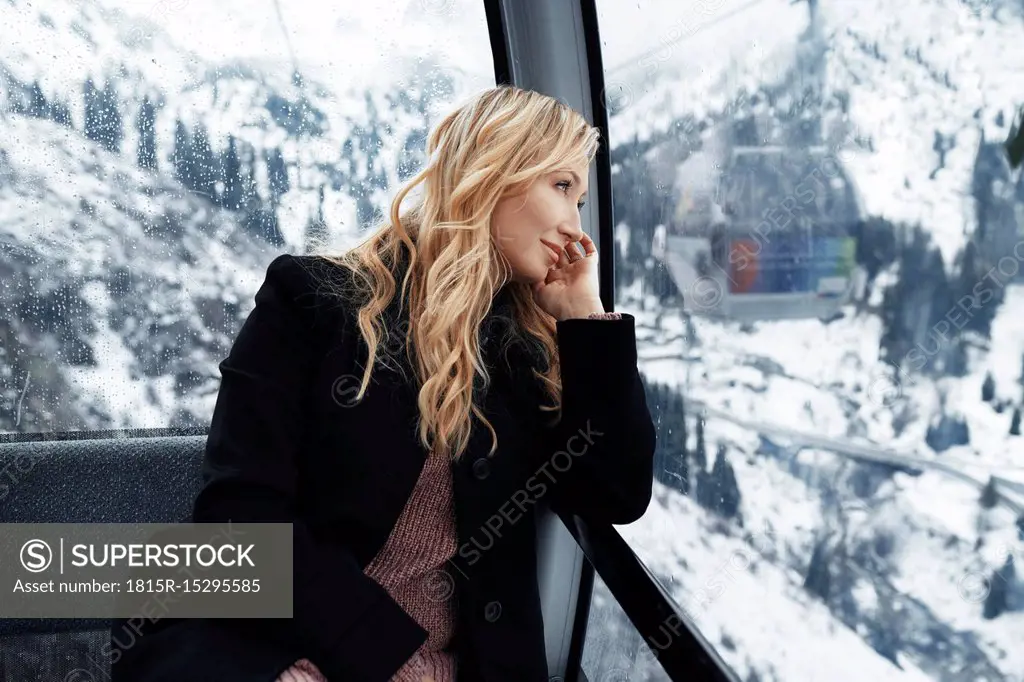 Switzerland, European Alps, Woman looking out at the mountain range from the cable car gondola