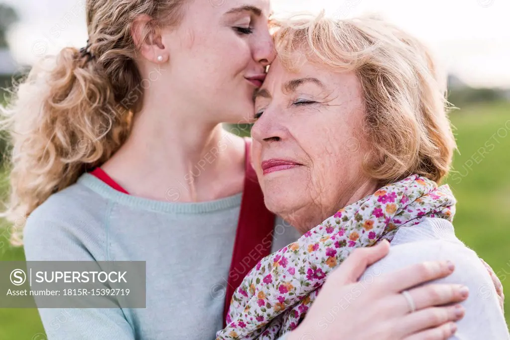 Granddaughter kissing her grandmother