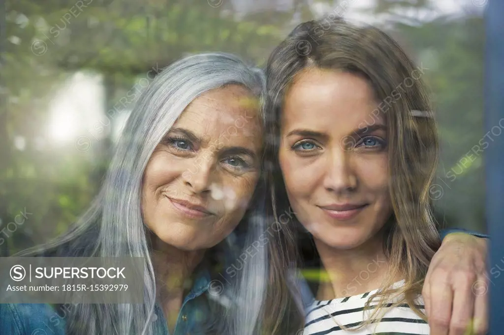 Mother and daughter looking out of window