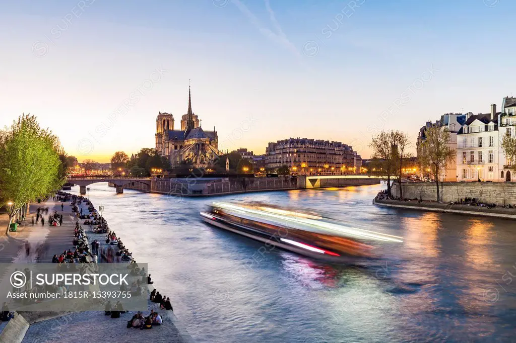 France, Paris, Tourist boat on Seine river with Notre Dame cathedral in background