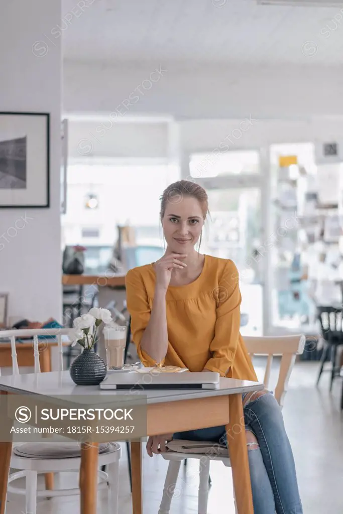 Young woman working in coworking space, taking a break