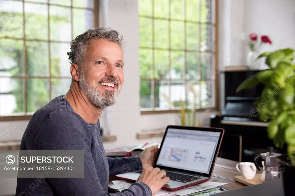 Mature man working in his home office at a loft apartment