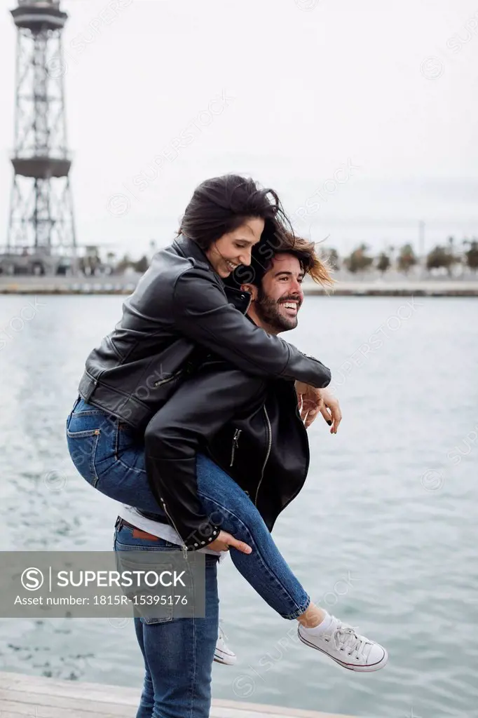 Spain, Barcelona, happy young couple having fun at the coast