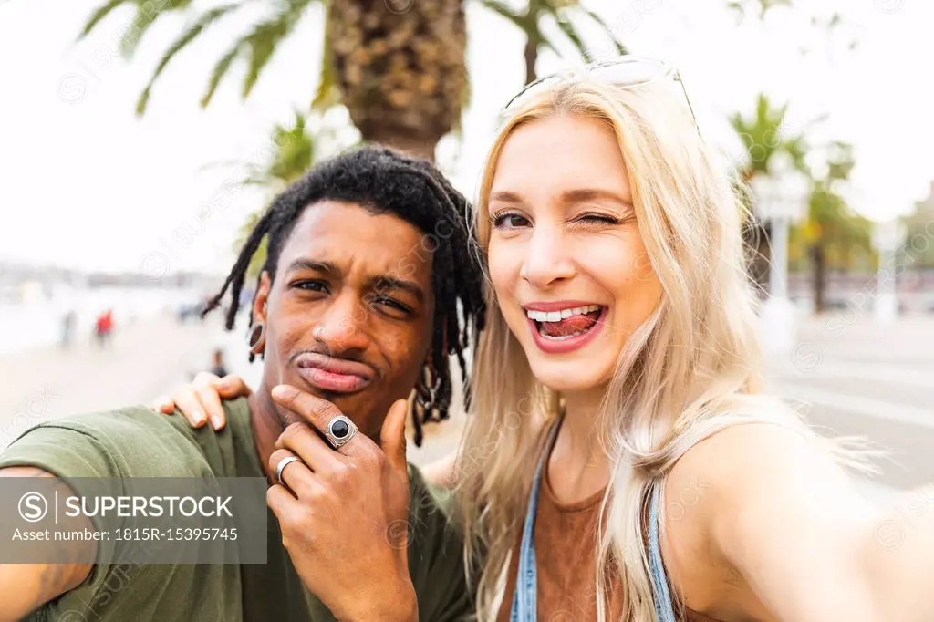 Portrait of multicultural young couple taking selfie