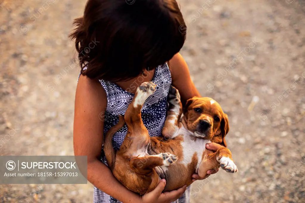 Girl holding puppy in her arms