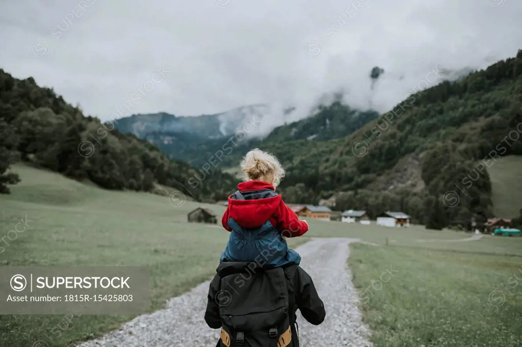 Austria, Vorarlberg, Mellau, mother carrying toddler on shoulders on a trip in the mountains