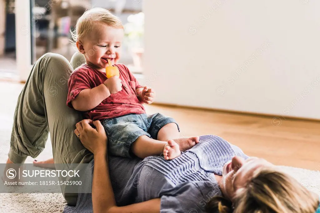 Mother and son at home eating ice lolly