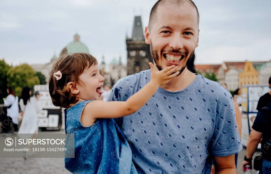 Czechia, Prague, father and little daughter having fun together on Charles Bridge