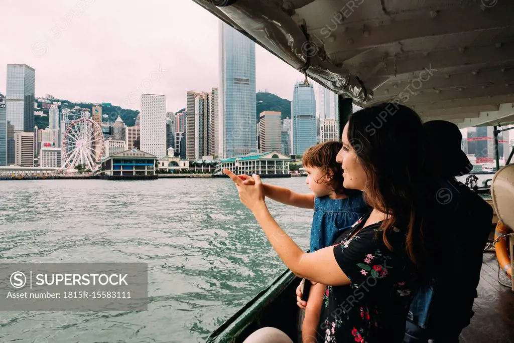 China, Hong Kong, mother and little daughter crossing the river by ferry from Kowloon to Hong Kong Island