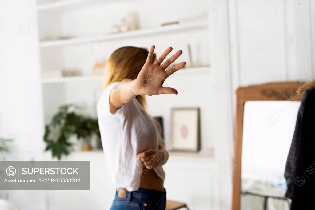 Abuse and violence against women, woman raising hand at home