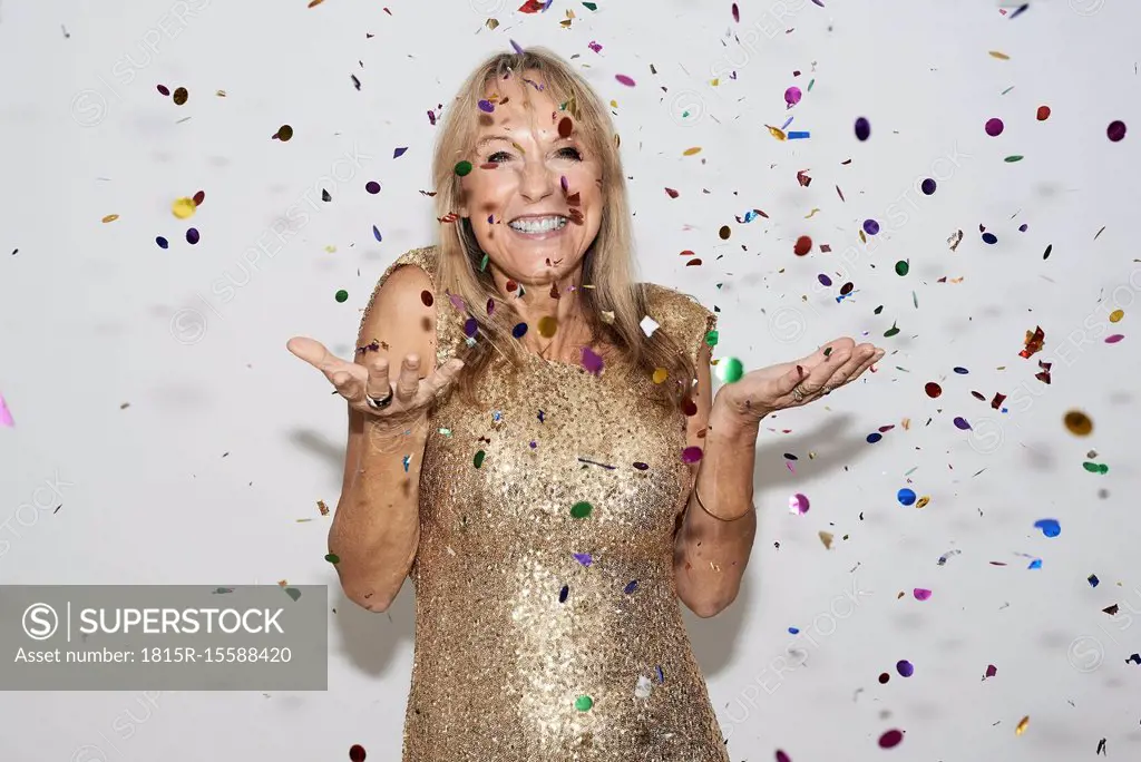 Senior woman wearing golden dress, celebtraing New Year's Eve