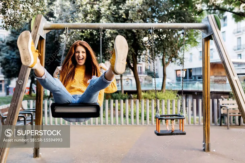 Spain, Barcelona, Red-haired girl playing the guitar in the city