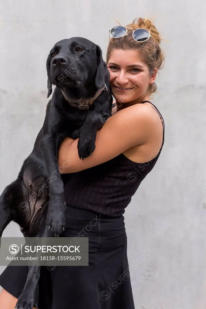 Portrait of happy young woman with her black dog