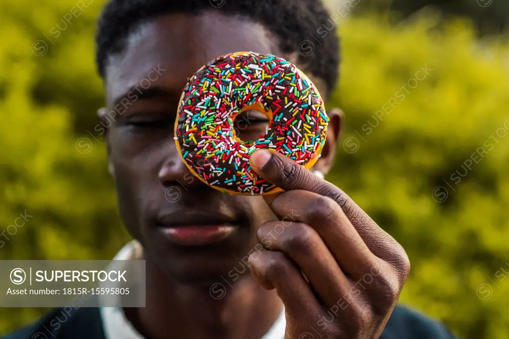 Young black man holding a chocolate cookie