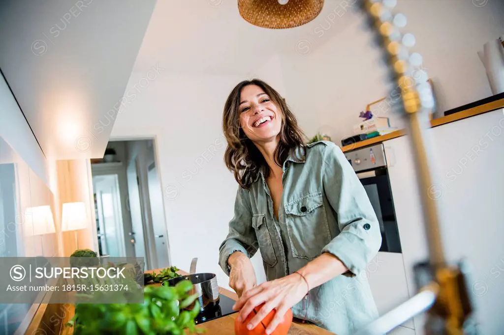 Laughing woman slicing pumpkin in her kitchen