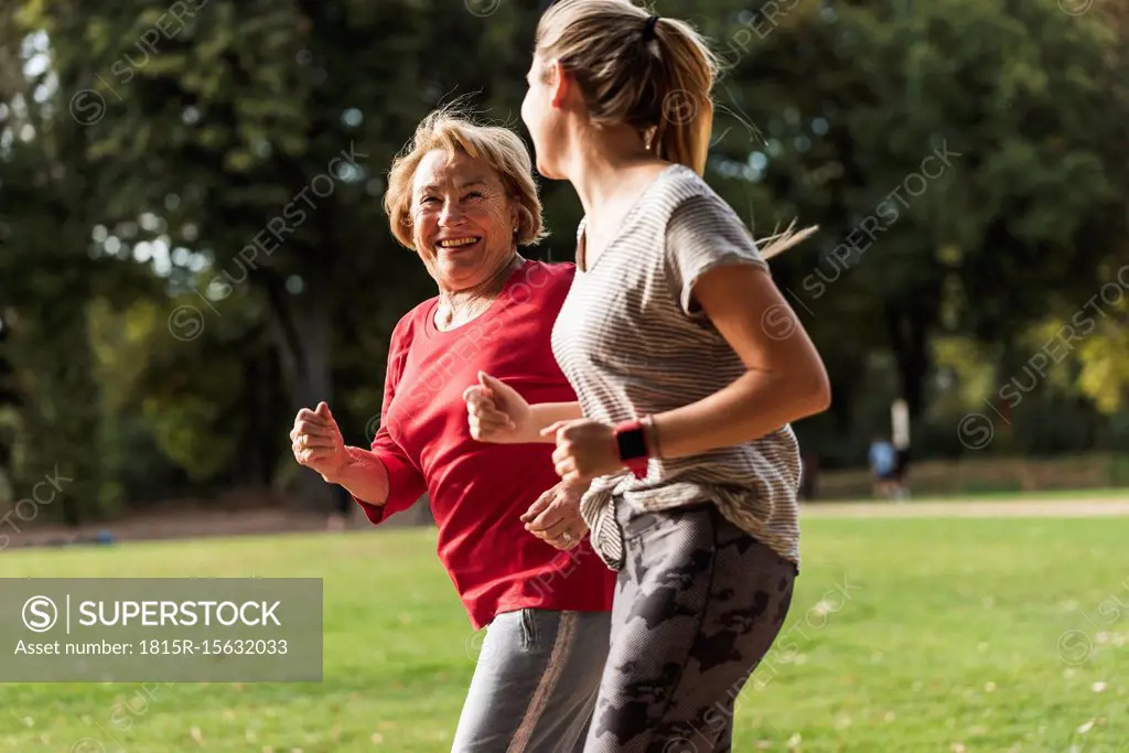 Granddaughter and grandmother having fun, jogging together in the park