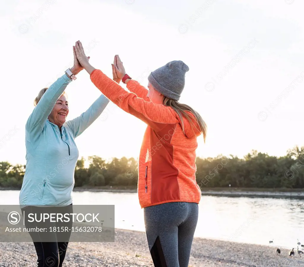 Grandmother and granddaughter high-fiving after training at the river