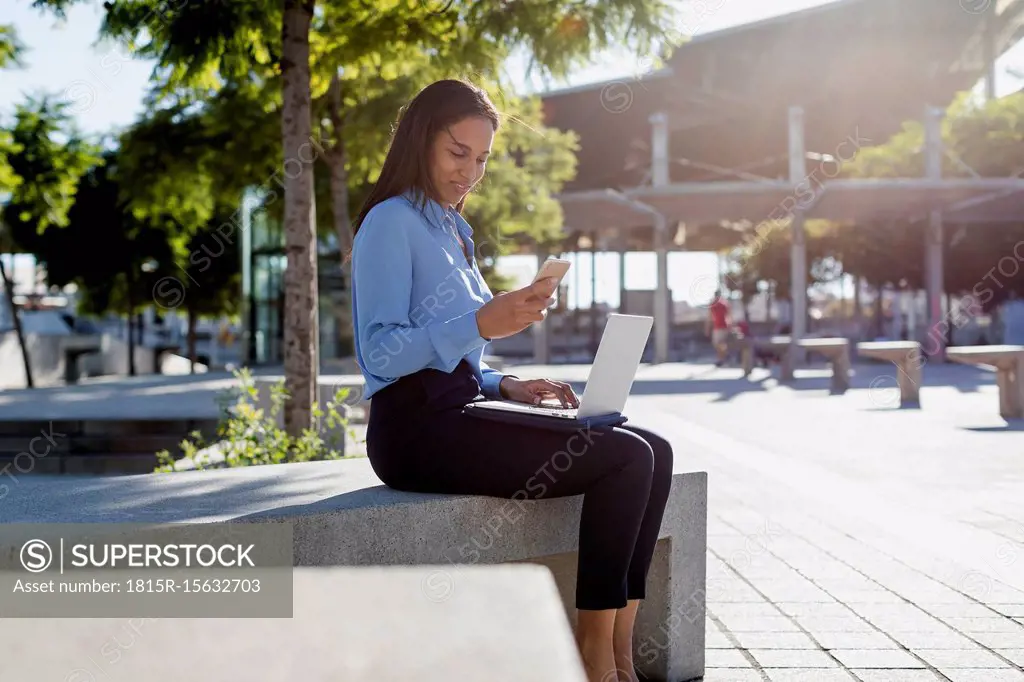Businesswoman using laptop and smartphone