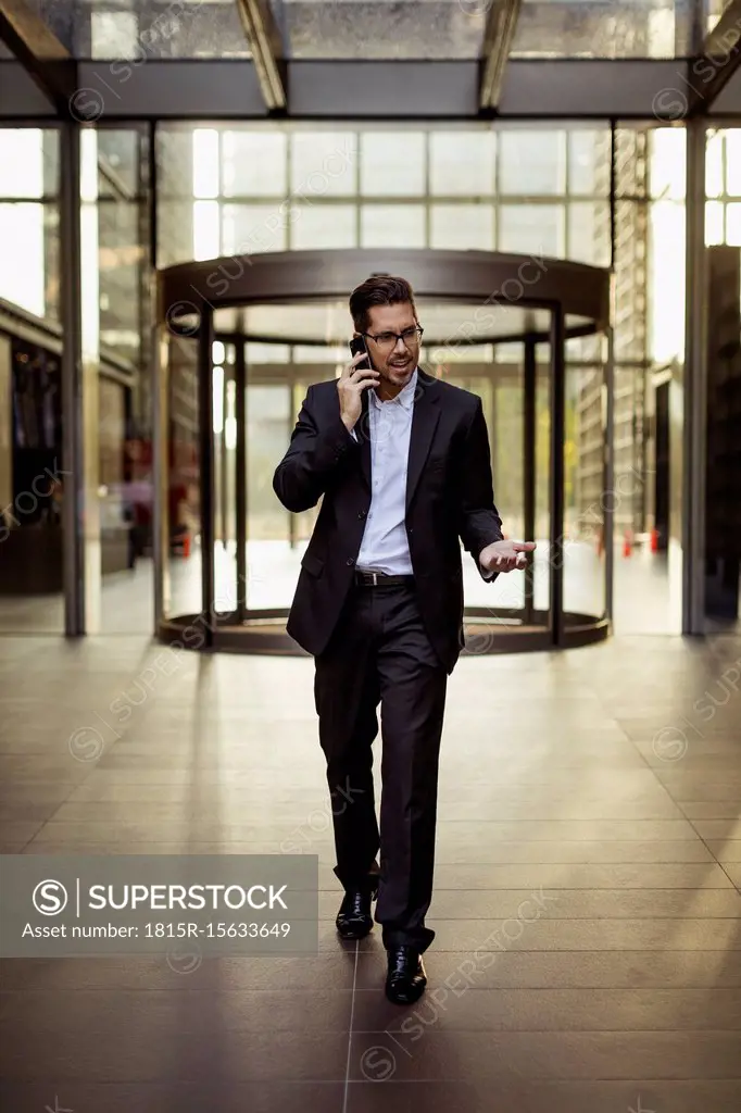 Businessman on cell phone in foyer of an office building