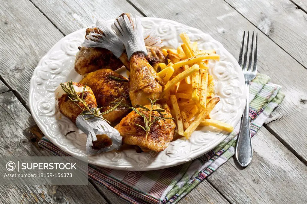 Chicken drums with french fries on plate