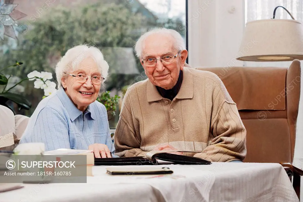 Senior couple watching old photographs at home