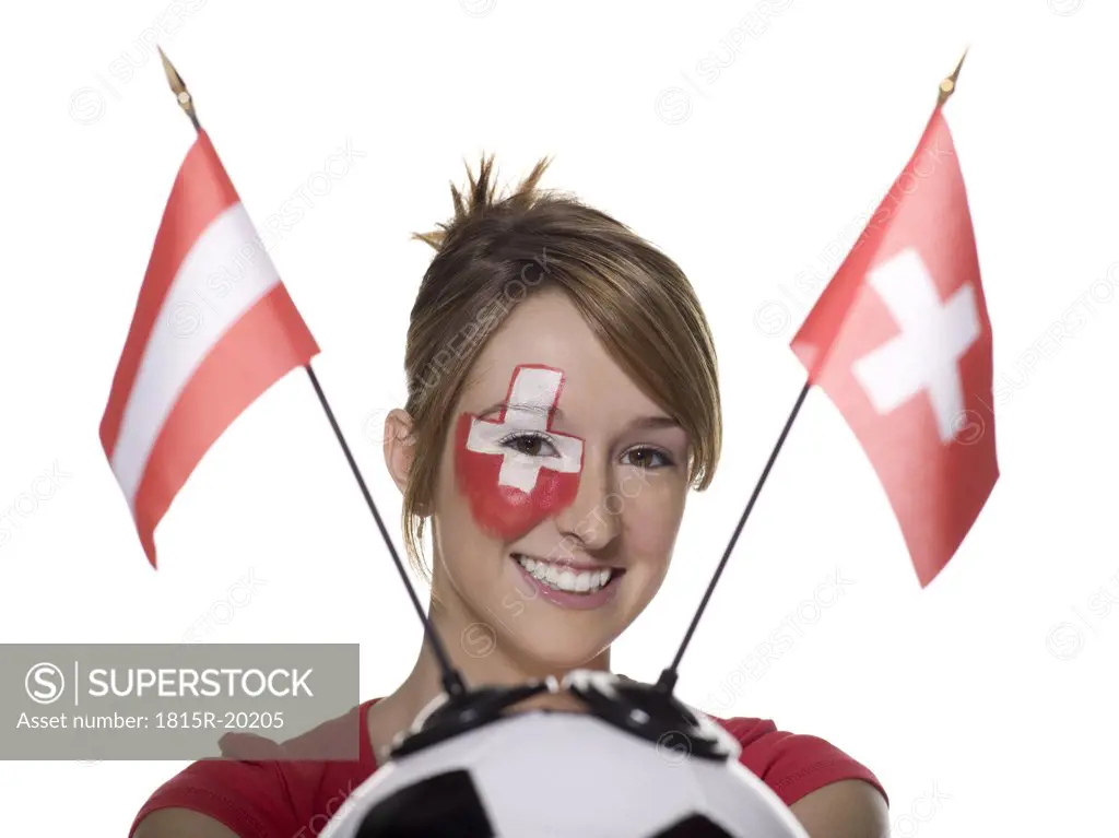 Woman with Swiss flag painted on face, holding football with flags