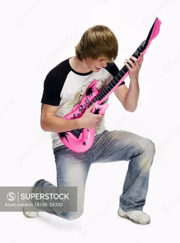 Teenage boy (16-17) with electric guitar, portrait