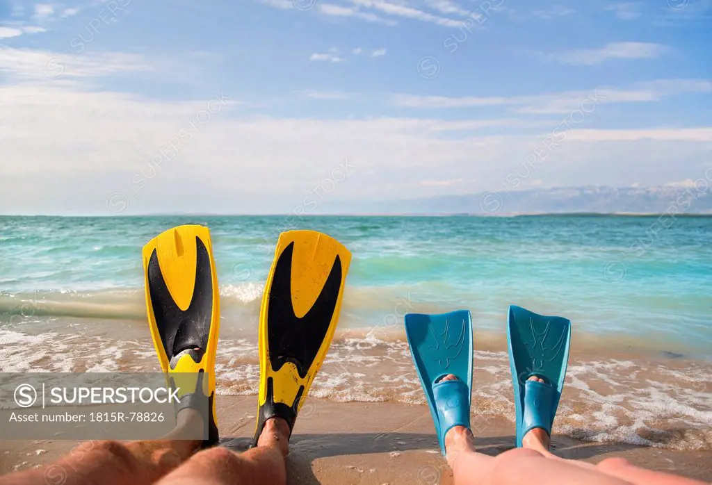 Croatia, Zadar, Couple with flippers relaxing on beach