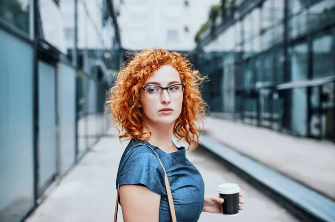 Young businesswoman holding take out coffee