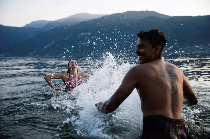 Happy young couple playing in a lake