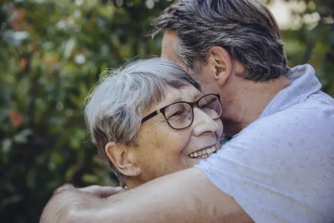 Adult son embracing his mother in the garden