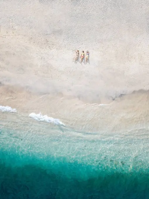 Aerial view of young women lying at the beach, Gili Air island, Bali, Indonesia