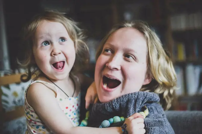 Portrait of mother and little daughter having fun together at home