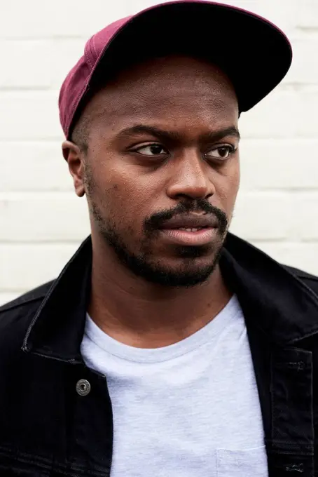 Portrait of mid adult man wearing denim jacket and basecap