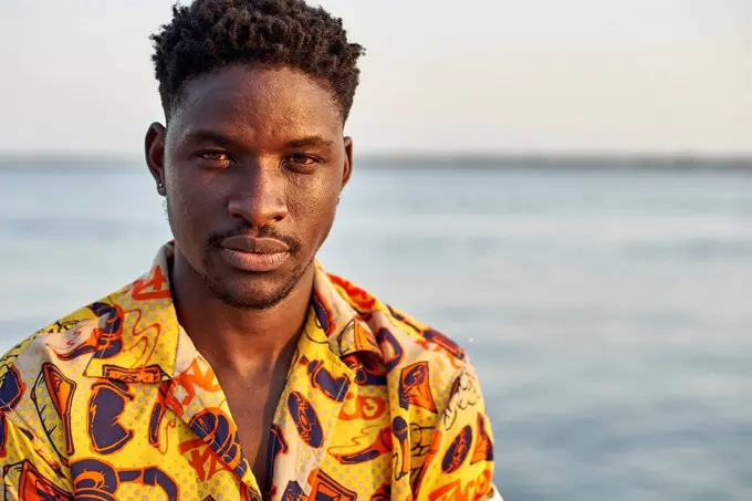 Young man standing at the sea, portrait