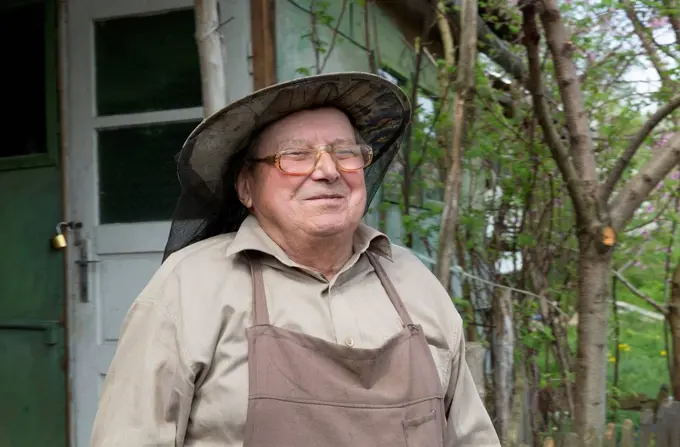 Rumania, Ciresoaia, Portrait of smiling beekeeper with beekeper's hood