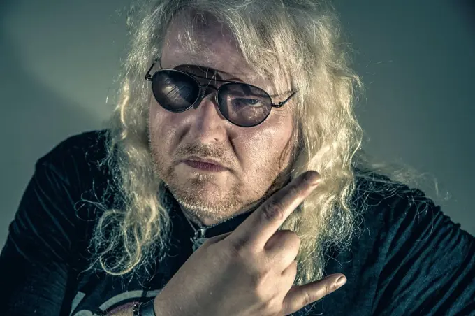 Portrait of blond rocker showing Rock And Roll Sign