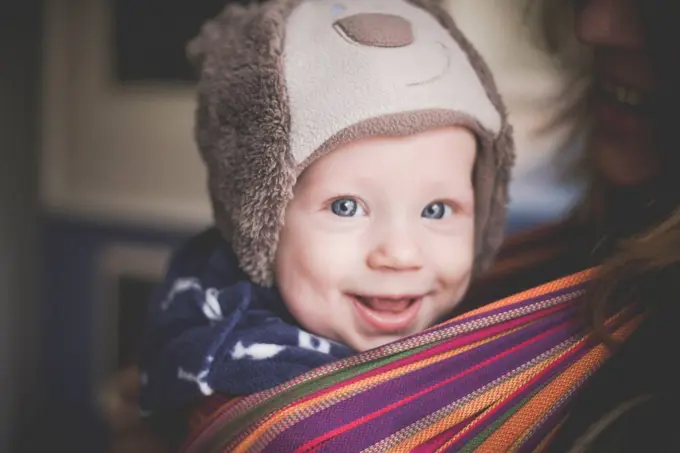 Portrait of happy baby boy in a sling