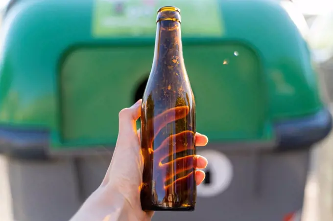 Close-up of man holding bottle for recycling