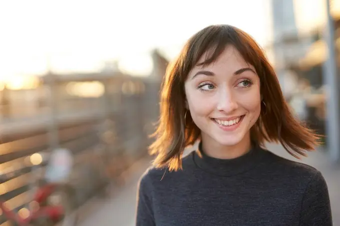 Portrait of smiling young woman at evening twilight