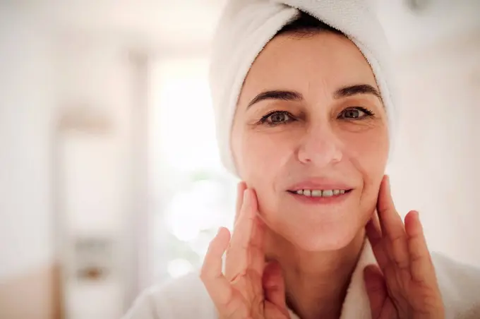 Portrait of smiling mature woman in a bathroom at home