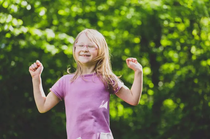 A jumping preschool girl with closed eyes