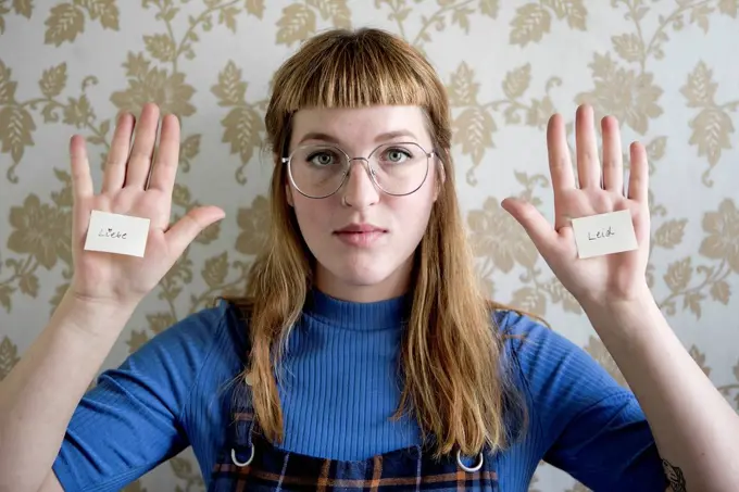 Student holding showing her hand, a note with the words love and suffer on her hands