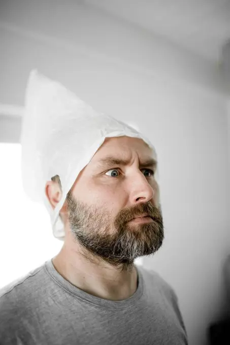 Portrait of angry man with plastic bag on his head