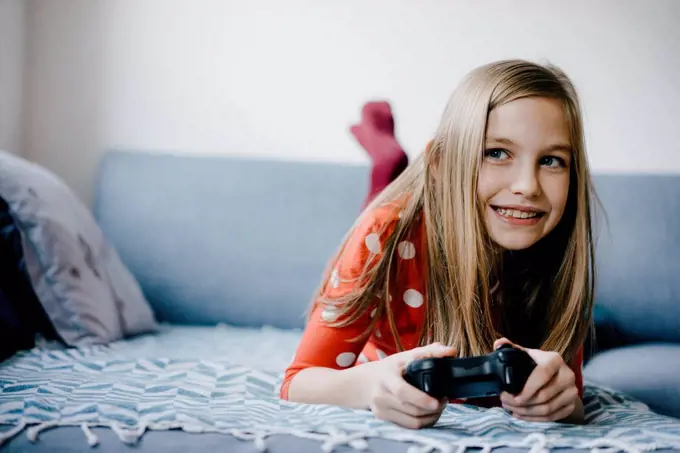 Happy girl playing video game at home