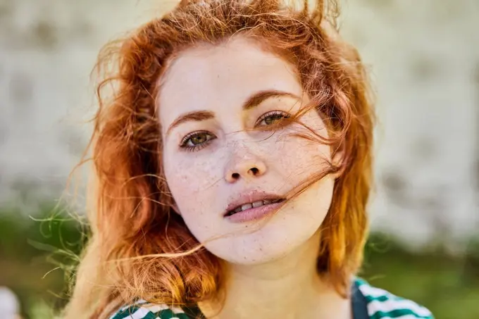 Portrait of redheaded young woman with freckles