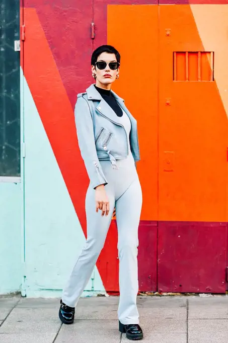 Fashionable young woman posing with colorful urban background